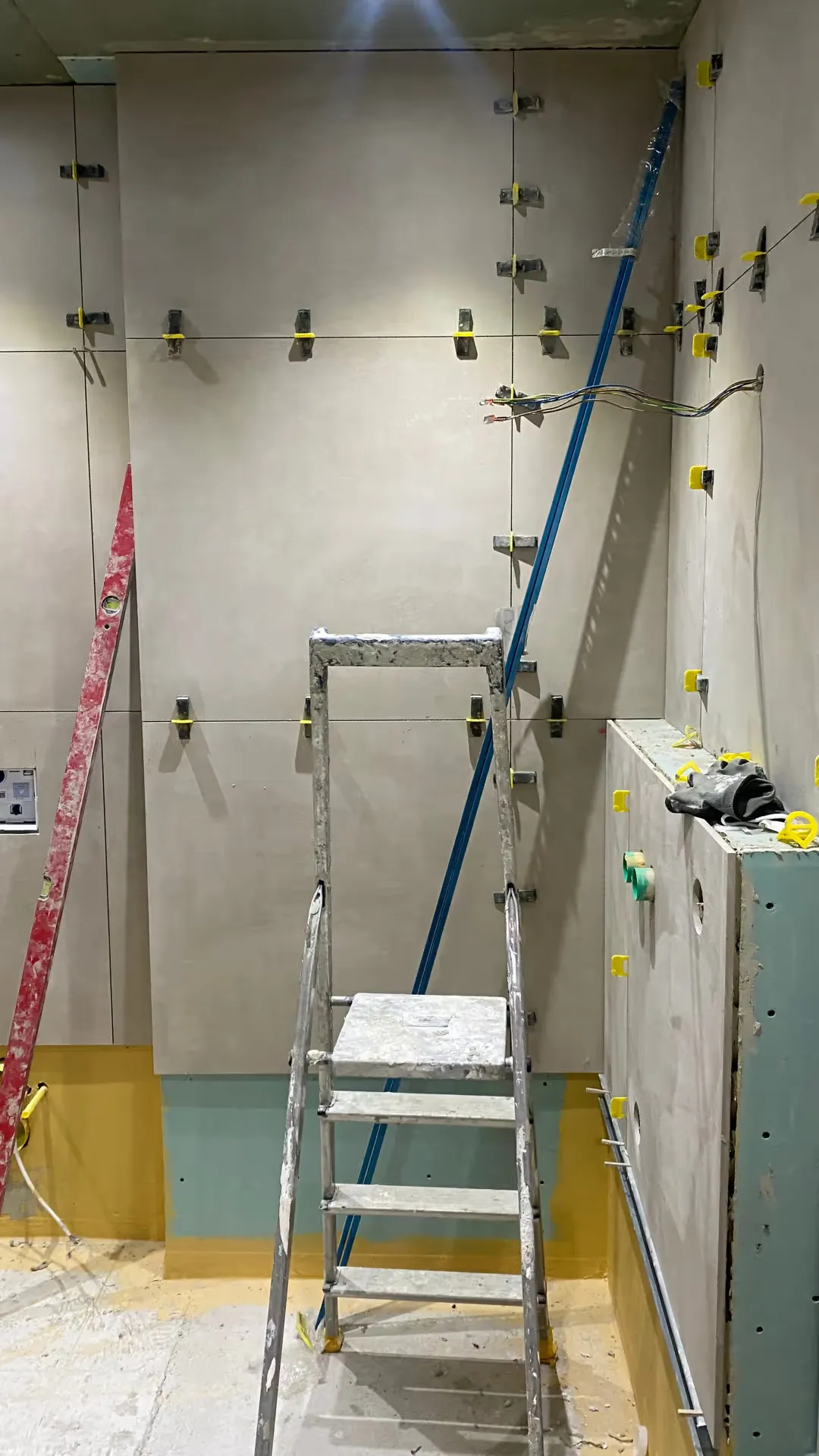 Frisch verlegte großformatige Wandfliesen im Bad, ausgerichtet mit Nivelliersystem.